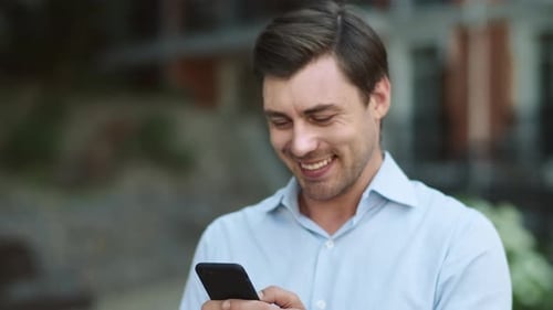 Closeup Businessman Using Smartphone at Street. Man Typing on Phone Outside