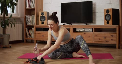 Woman Wipes Sweat After Workout on Yoga Mat