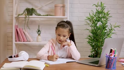 Girl Studying at Desk with Laptop and Headphones