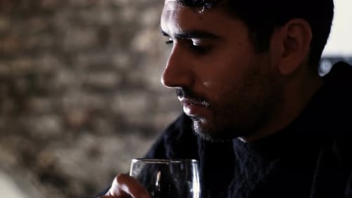Stressed Thoughtful Young Man Drinking Alone in A Pub