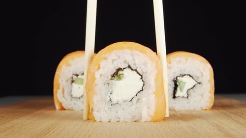 Sushi Roll Picked Up with Chopsticks