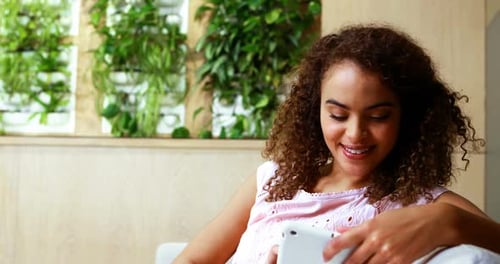 Woman Smiling While Using Tablet at Home