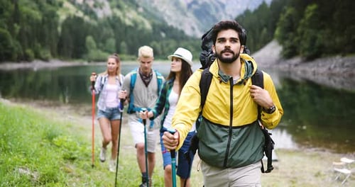 Friends Hiking near Mountain Lake on Sunny Day