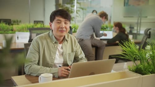 Handsome Professional Working at Laptop in Modern Office