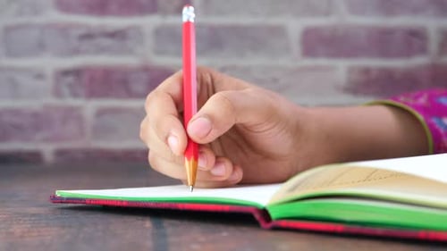 Close Up of Women Hand Writing on Notepad