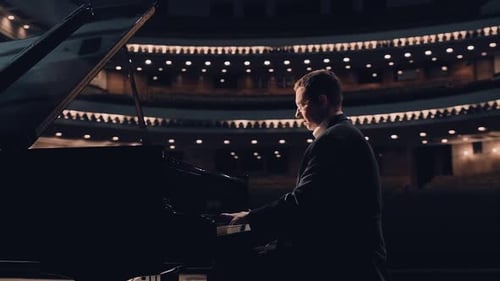 Elegant Man Plays Piano in Empty Theater