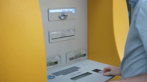 Close Up of Man's Hand Insert ATM Card Into Automated Teller Machine (Automatic Banking Machine) To