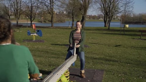 Family playing together at seesaw in public playground, Zagreb, Croatia.