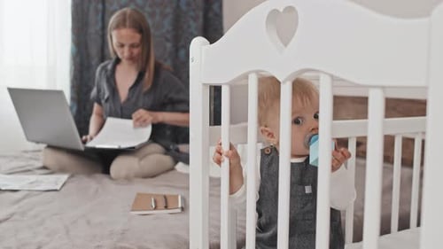 Focused Mother Working at Home with Baby