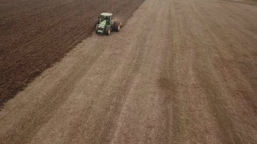 Tractor Tilling Field on a Farm, Aerial View
