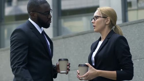 Two Multiracial Colleagues Chatting Near Office Building During Coffee Break