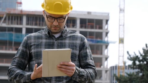 Architect on Building Site Using Digital Tablet.