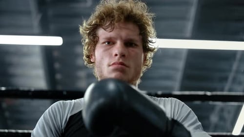 Angry Kickboxer Looking at Camera at Gym. Sportsman Checking Boxing Gloves
