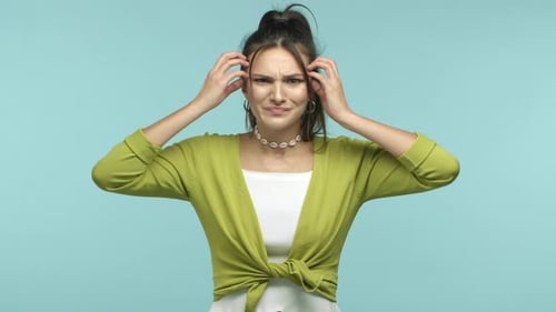 Раздраженная и напряженная молодая женщина, испытывающая давление, показывает разум, удар головой, взрыв, жест и говорит