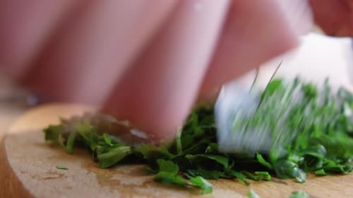 Hands of Chef Cutting Green Parsley with Knife