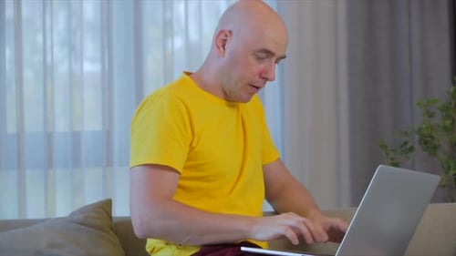 Adult Typing on Laptop While Relaxing at Home