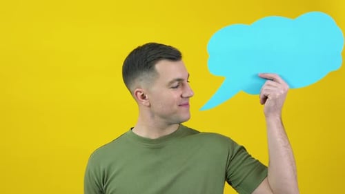 Caucasian Middleaged Man in a Green Tshirt Holding a Cloud for the Insert Text and Smiling in the