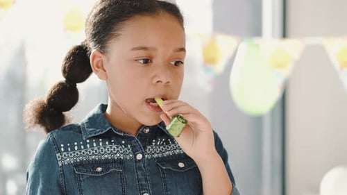Girl Blowing Party Favor at Birthday Celebration