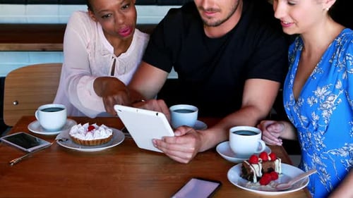 Friends Looking at Tablet in Cafe