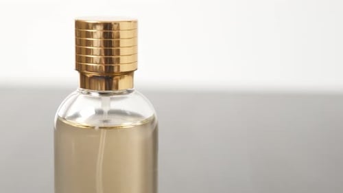 Luxourius perfume bottle with golden cap and liquid details slow tilt 4K 2160p 30fps UltraHD footage