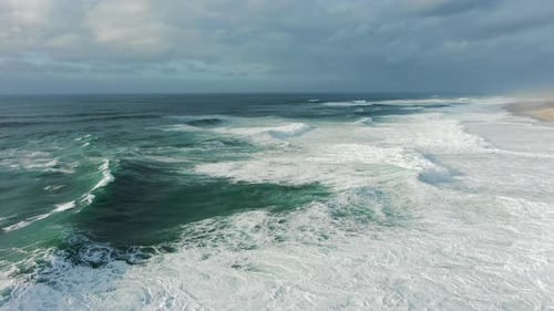Azure Waves with Heavy White Foam Roll on Beach Aerial View