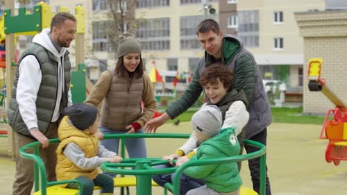 Kaukasische Eltern und Kinder haben Spaß auf Karussell