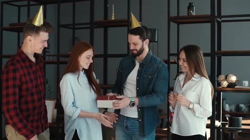 Happy Business Team of Office Employees Giving Gift or Presents To Young Female Coworker