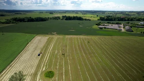 Tractor Harvesting Crop in Rural Field Aerial View