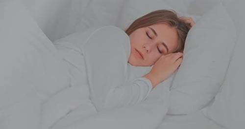Woman Sleeping Peacefully in All-White Bed