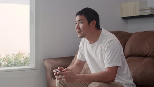 Adult Playing Video Game on Couch Indoors