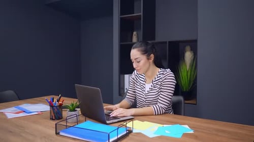 Young Woman Celebrating Success At Her Desk
