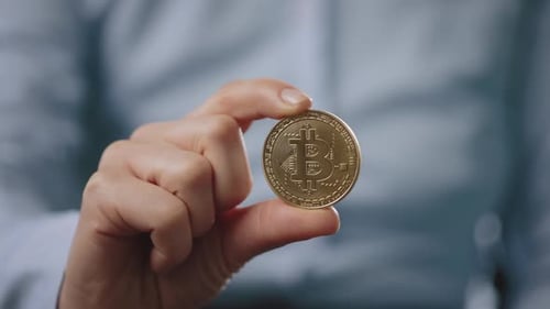 Adult Holding Bitcoin Cryptocurrency Coin Close Up