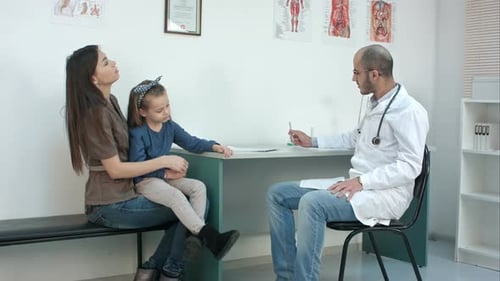 Doctor Consulting with Mother and Child in Office