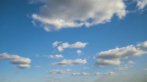 Zeitrafferaufnahmen von sich schnell bewegenden weißen Wolken auf blauem, klarem Himmel.