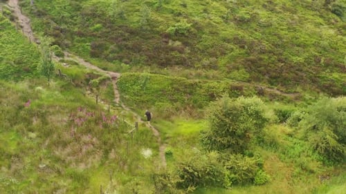 A young man running up a steep mountain path