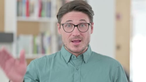 Mann mittleren Alters winkt in die Kamera