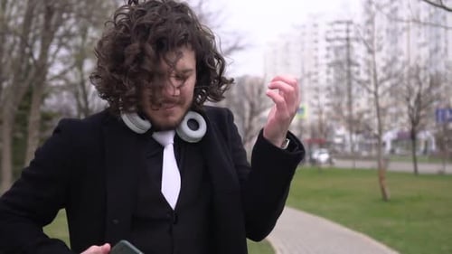 Man Reacts to Phone Message in City Park