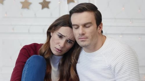 Portrait of Sad Couple Watching Video in Living Room
