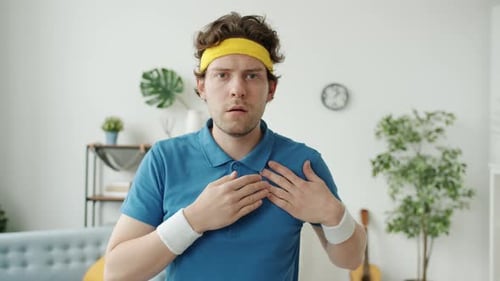 Young Adult Man Grabbing Chest and Making Ok Sign