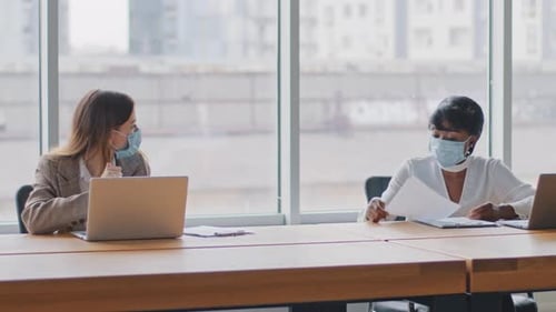 Two Multiracial Female Worker Caucasian Woman Manager and African Businesswoman Sitting in Office at