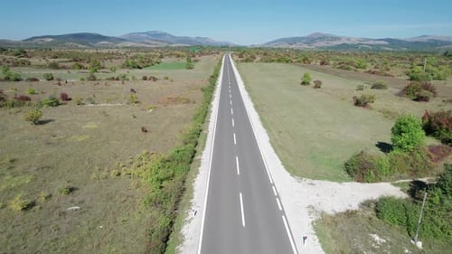 Empty Asphalt Road on the Plateau Between Green Fields Highland Way Aerial View