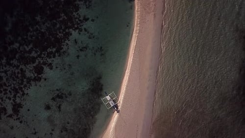 Aerial above boats docked at beautiful sandbar, with turquoise water, beach and waves. Bird’s eye vi