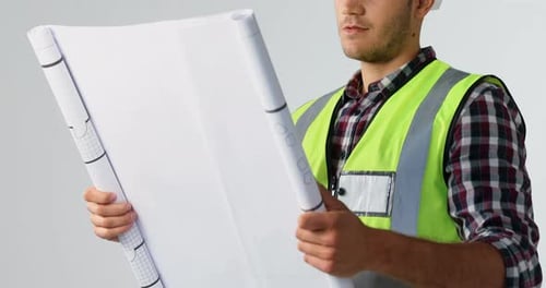 Male architect looking at blueprint against white background 4K 4k
