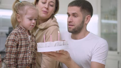 Family Celebrates Birthday With Cake And Candles
