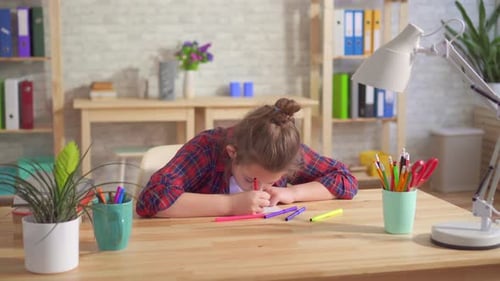 Focused Child Drawing with Markers at Desk