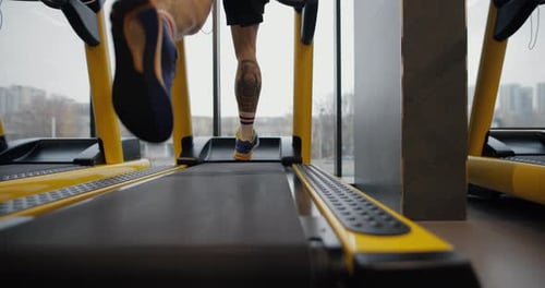 Legs of Man Running on a Treadmill in Gym Slow Motion