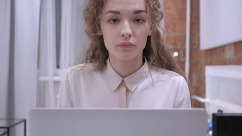 Woman Looking at a Laptop in an Interior Room