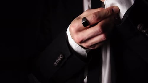 Macro View of a Man Who is Fastening a Button on the Sleeve of His Costume