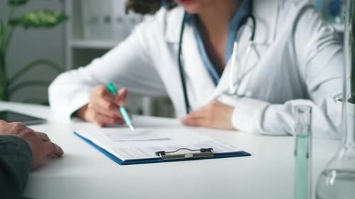 Doctor writes on clipboard gives to patient