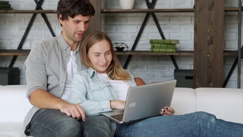 Affectionate Couple Uses Laptop Together in Modern Home